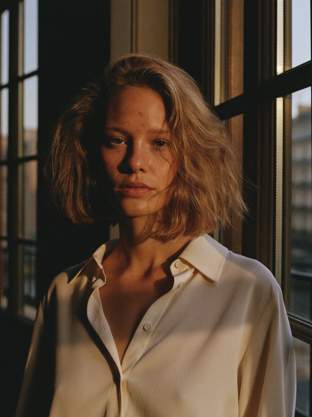 Aurélie, portrait by a tall Parisian window