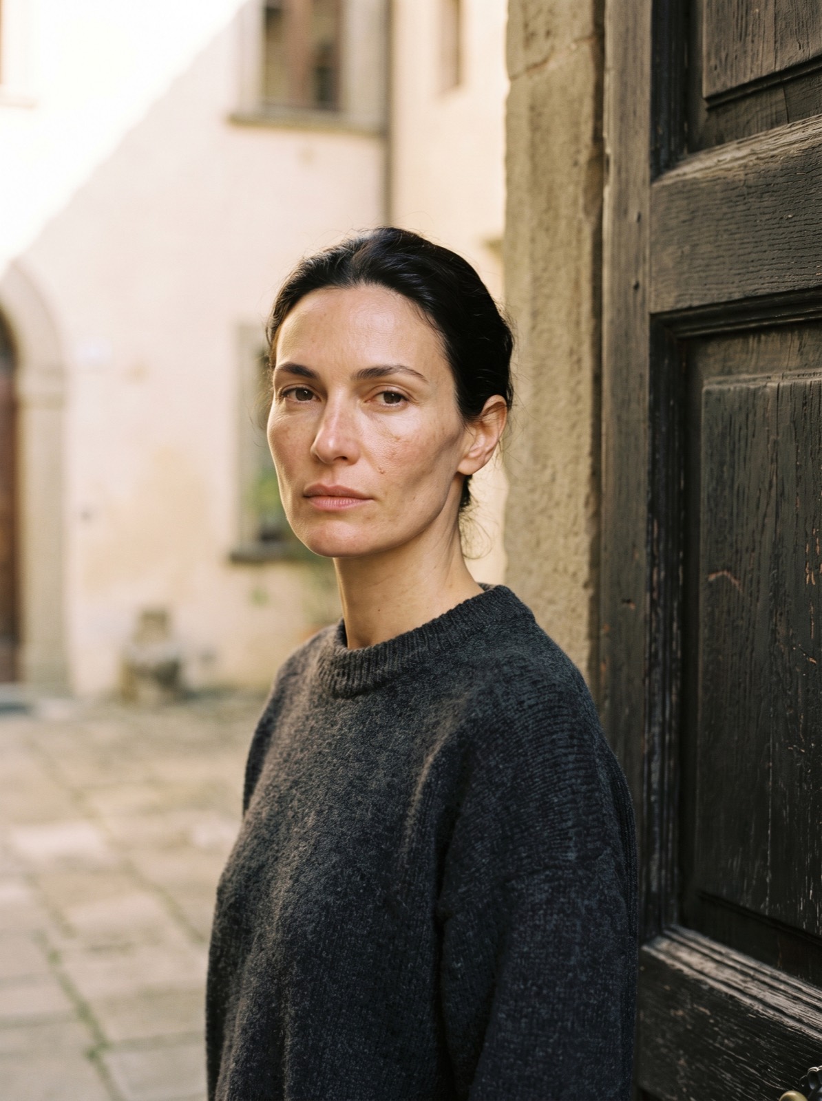 Mara, portrait against a warm plaster wall