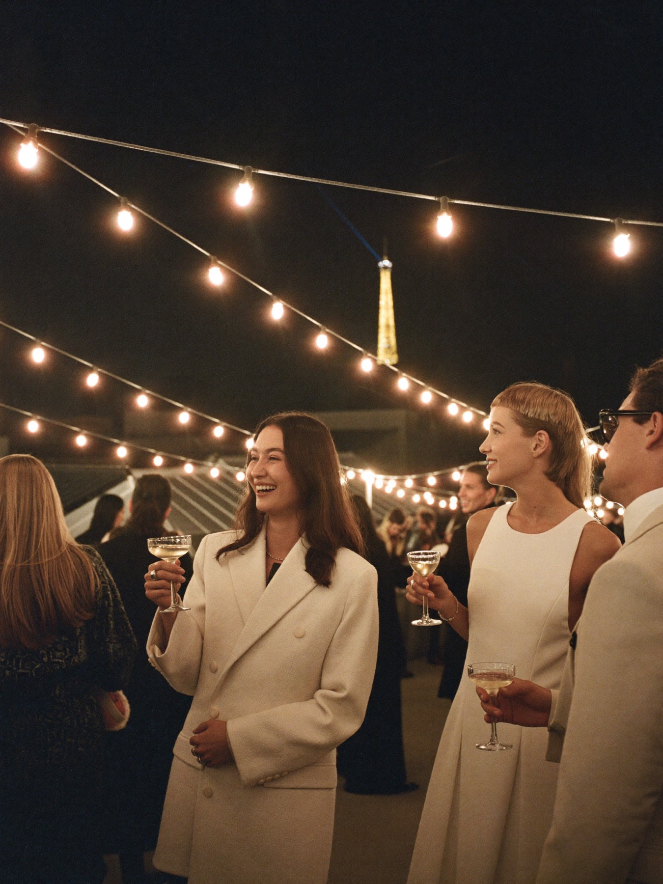 Guests at a rooftop party in Paris at night